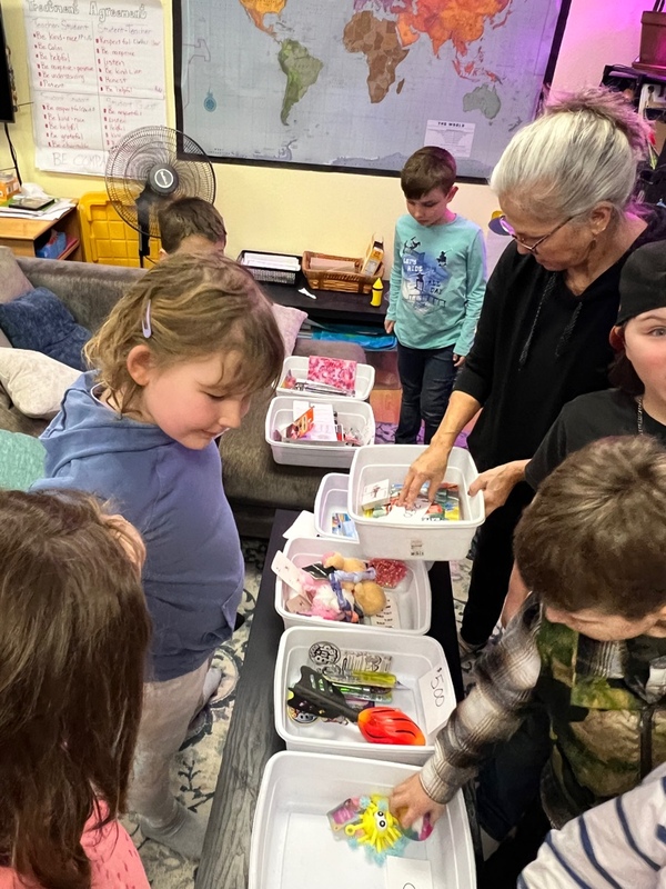 Children looking at containers filled with toys